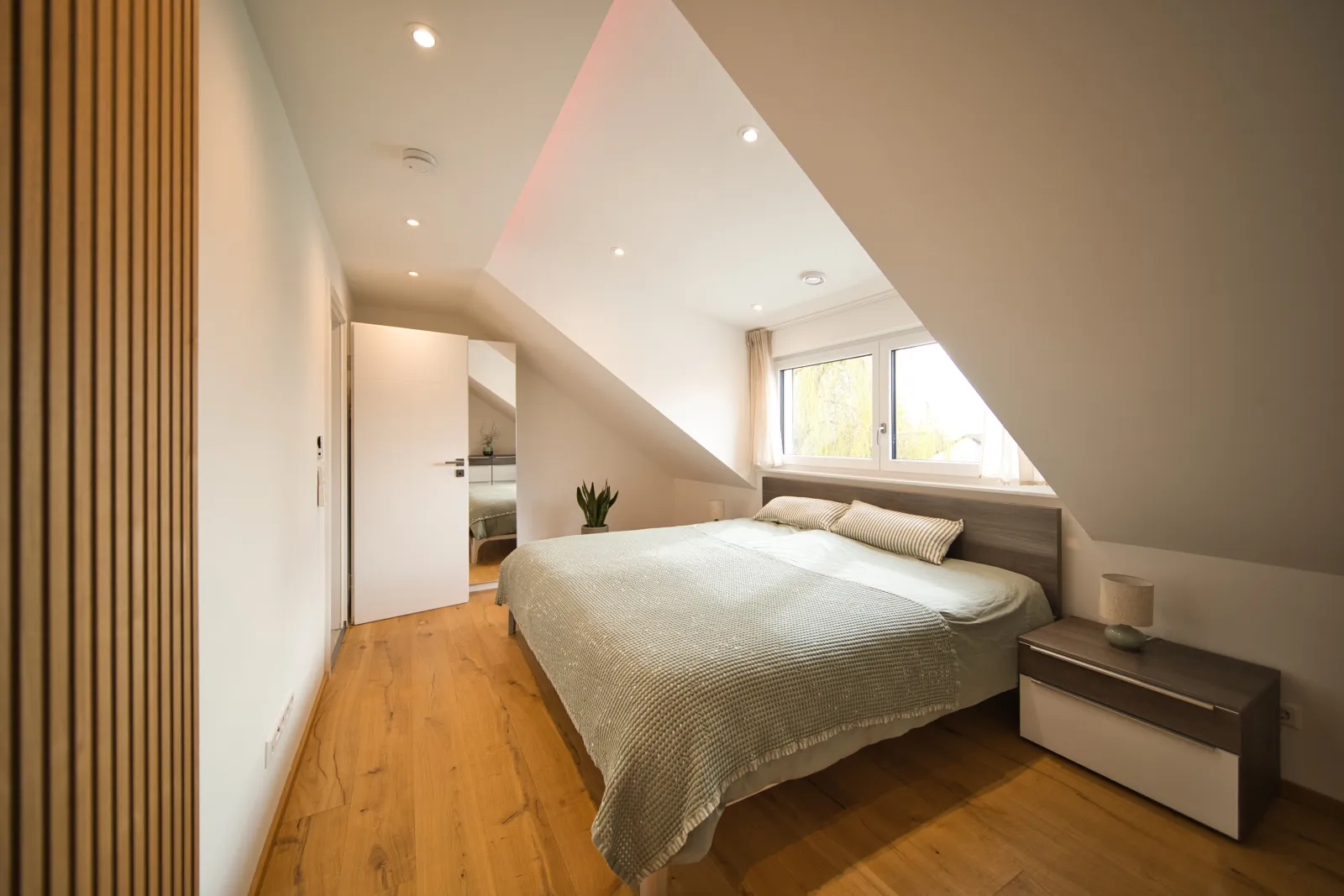 Schlafzimmer mit Doppelbett und Holzlamellen